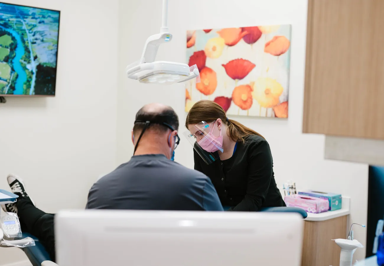 Dentist and hygienist caring for a patient in a treatment room at CrossPointe Dental